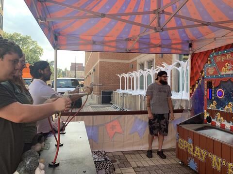Students playing a carnival shooting game