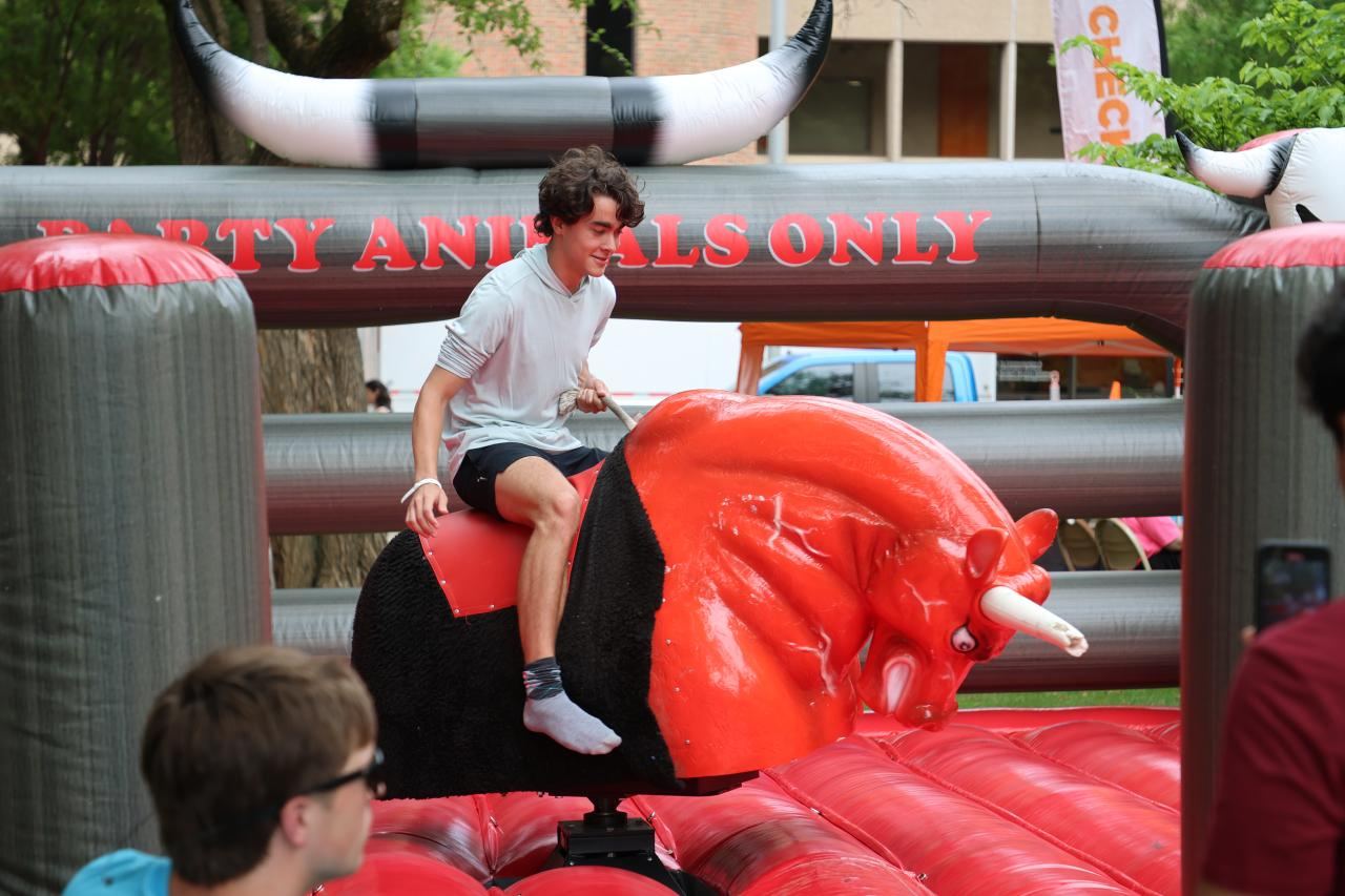 Student riding the mechanical bull